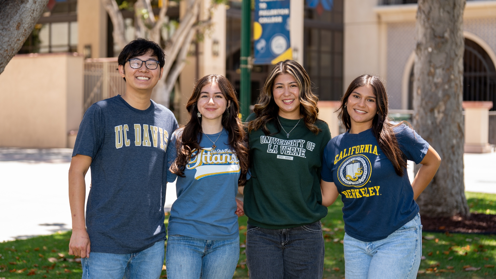 A group of Fullerton College students stands wearing T-shirts representing the colleges to which they will soon be transferring.
